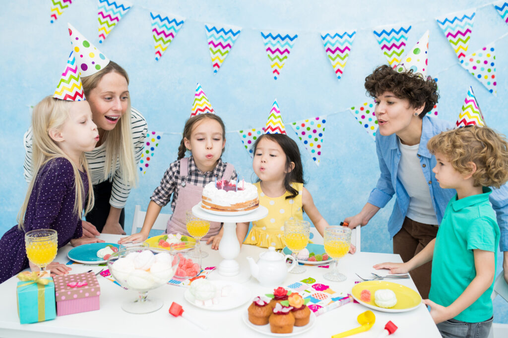 Kids blowing out candles at birthday party