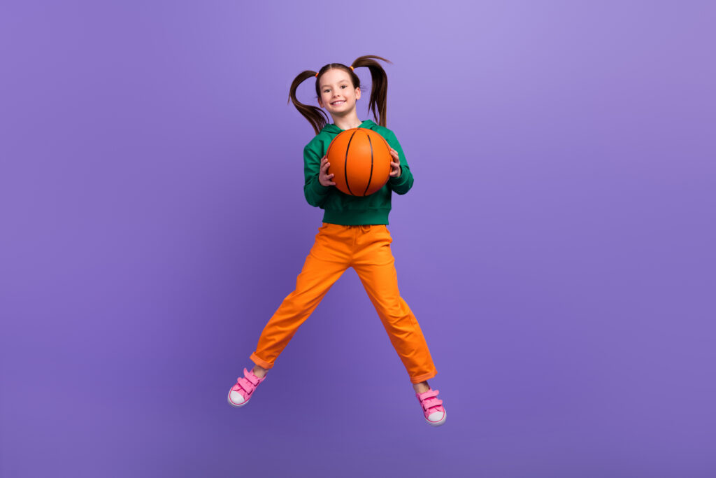 girl jumping with basketball