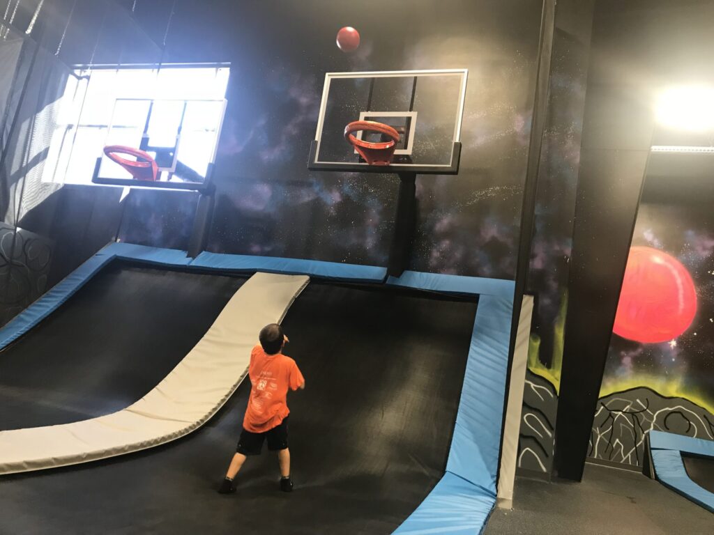child playing trampoline basketball at Elevate Trampoline Park in Milan